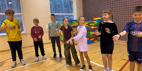 Powiększ grafikę: Dzieci tańczą na sali gimnastycznej.