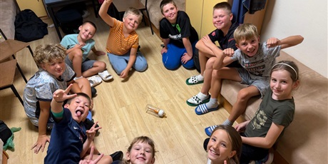 Powiększ grafikę: Uczniowie siedzą na podłodze w jednym z pokoi i uczestniczą we wspólnej zabawie.