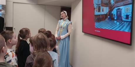 Powiększ grafikę: Przewodniczka ubrana w strój z epoki opowiada uczniom o codzienności gdańskich mieszczan.