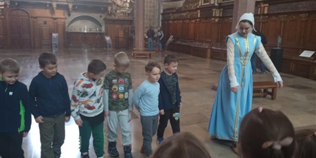 Powiększ grafikę: Panienka z Okienka - przewodniczka oprowadza dzieci po Dworze Artusa w Gdańsku.