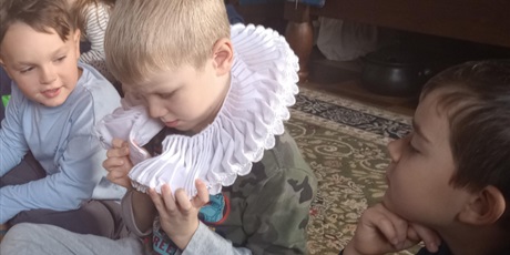 Powiększ grafikę: Chłopiec nakłada na szyję kołnierz, czyli ozdobę noszoną przez gdańskich kupców