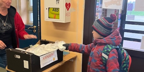 Powiększ grafikę: Dziecko wkłada kanapkę do pojemnika.