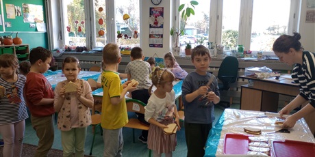 Powiększ grafikę: Dzieci z przygotowanymi kanapkami czekają w kolejce do jej zapakowania.