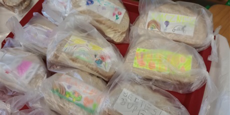 Powiększ grafikę: Na tacy leżą przygotowane przez dzieci kanapki. Mają one kolorowe napisy i znajdują się w woreczkach śniadaniowych.