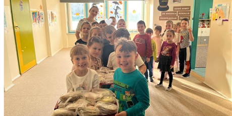 Powiększ grafikę: Grupa 6-latków niesie tacę z przygotowanymi przez siebie kanapkami. Wszyscy są bardzo radośni i zadowoleni z pracy.