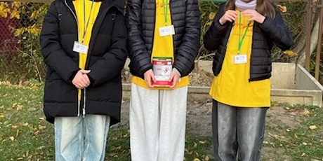 Powiększ grafikę: Troje dzieci - wolontariuszy stoi z puszką, do której zbierają datki. Dzieci ubrane są w żółte koszulki symbolizujące hospicjum.