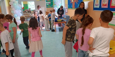 Powiększ grafikę: Grupa dzieci na korytarzu szkolnym. Część dzieci wykonuje testy sprawnościowe.