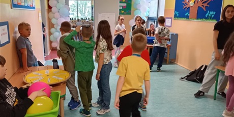 Powiększ grafikę: Grupa dzieci na korytarzu szkolnym. Część dzieci wykonuje testy sprawnościowe.