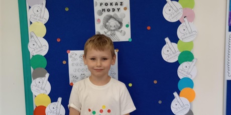 Powiększ grafikę: Chłopiec prezentuje swoje ubranie z akcentem kropki.