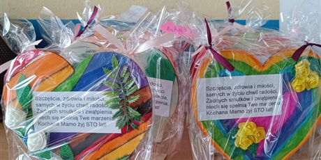 Powiększ grafikę: Dwa udekorowane przez dzieci kolorowe serca stojące obok siebie na stole.