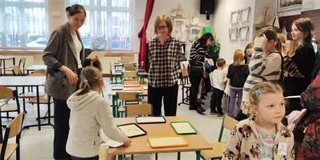 Powiększ grafikę: Przyszli uczniowie szkoły odwiedzają wraz z rodzicami stołówkę szkolną, rysują tam w kaszy, a rodzice uzyskują wyczerpujące odpowiedzi na pytania związane z funkcjonowaniem szkoły. 