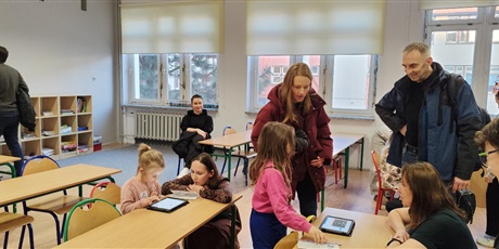 Powiększ grafikę: Przyszli uczniowie naszej szkoły wykonują zadanie z jezyka angielskiego pod kierunkiem nauczyciela pracując na tabletach.