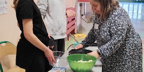 Powiększ grafikę: Wolontariuszki naszej szkoły pod okiem nauczycielki przygotowują popcorn dla gości szkoły.