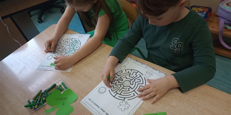Powiększ grafikę: Dzieci szukają drogi w labiryncie. Najpierw pokazuja palcem a później rysują zieloną kredką.