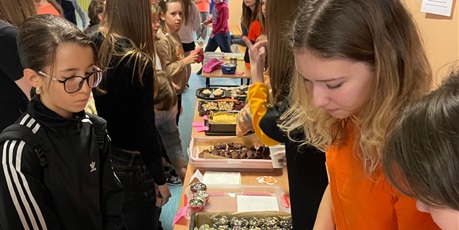 Powiększ grafikę: Uczniowie klasy 7 A ubrani na pomarańczowo sprzedają domowe wypieki z okazji Dnia Tumbo,