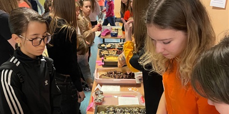 Powiększ grafikę: Uczniowie klasy 7 A ubrani na pomarańczowo sprzedają domowe wypieki z okazji Dnia Tumbo,