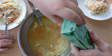 Powiększ grafikę: Cztery dłonie kolegów, którzy dzielą się sokiem.