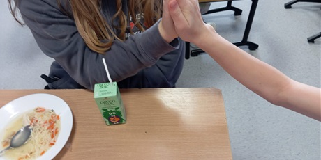 Powiększ grafikę: Dłonie dwóch koleżanek, które przybijają sobie piątki.