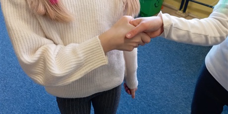 Powiększ grafikę: Dwie dłonie koleżanek, które się witają.