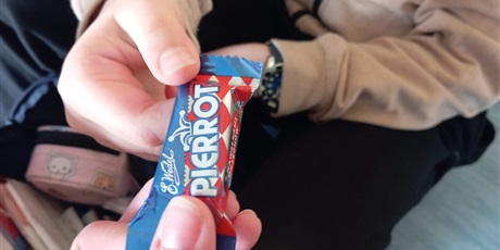 Powiększ grafikę: Dłonie dzieci dzielących się słodyczami.