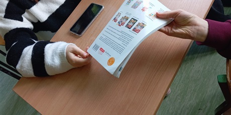 Powiększ grafikę: Kolega podaje książkę koleżance.