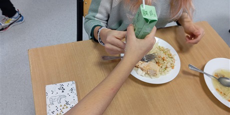 Powiększ grafikę: Dziewczynka dzieli się sokiem z drugą dziewczynką.