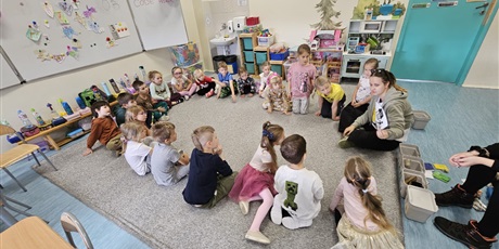 Powiększ grafikę: Dzieci z oddziału przedszkolnego siedzą w kole i rozmawiają z prowadzącą.