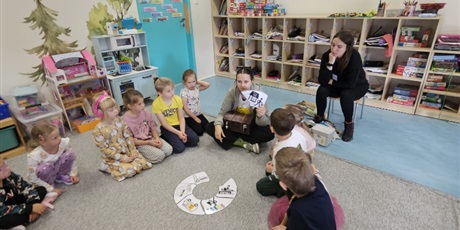 Powiększ grafikę: Prowadząca zajęcia omawia każdy fragment cyklu recyklingu. Dzieci słuchają siedząc w kole na podłodze.