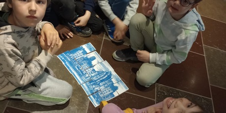 Powiększ grafikę: Grupa dzieci ułożyła puzzle. Na obrazku widać gdański Żuraw oraz kamieniczki.