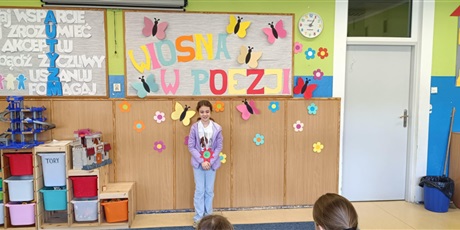 Powiększ grafikę: Dziewczynka stoi przodem i recytuje wiersz