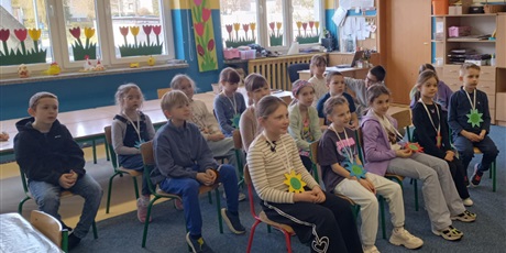 Powiększ grafikę: Grupa dzieci siedzi na krzesełkach w świetlicy.