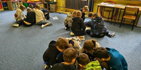 Powiększ grafikę: Trzy grupy dzieci siedzą na dywanie i wspólnie układają puzzle przedstawiające mapę Europy.