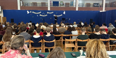 Powiększ grafikę: Jury i publiczność wsłuchana w śpiew. Na scenie młoda artystka śpiewa do mikrofonu.