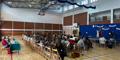 Powiększ grafikę: Na scenie śpiewa duet. Jury i publiczność wsłuchują się w śpiew.