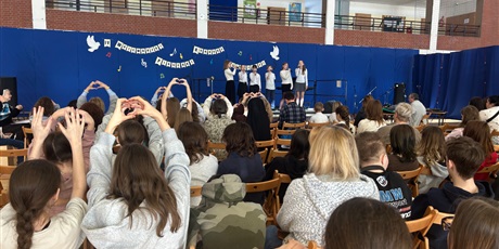 Powiększ grafikę: Na scenie śpiewa zespół. Publiczność przesyła im serca.