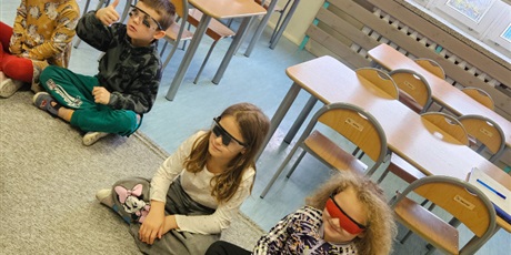 Powiększ grafikę: Na zdjęciu widać dzieci, które mają założone okulary utrudniające im widzenie.