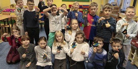 Powiększ grafikę: Grupa dzieci pozuje do zdjęcia. W rękach trzymają wykonaną własnoręcznie świąteczną wydrapywankę. 