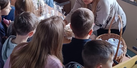 Powiększ grafikę: Kilkoro dzieci otacza nauczycielki podczas kiermaszu.