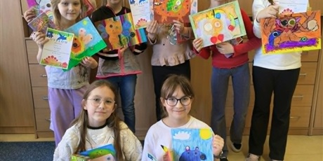 Powiększ grafikę: Grupa dzieci pozuje do zdjęcia. W dłoniach trzymają dyplomy, nagrody i swoje prace konkursowe przedstawiające postać Rupaka.