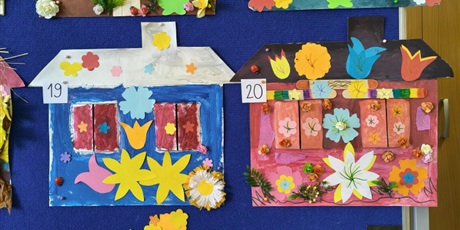 Powiększ grafikę: Tablica, na której wiszą kolorowe prace plastyczne przedstawiające domy pani wiosny.