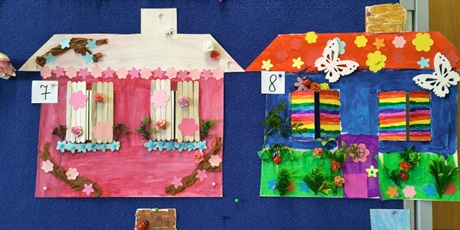 Powiększ grafikę: Tablica, na której wiszą kolorowe prace plastyczne przedstawiające domy pani wiosny.