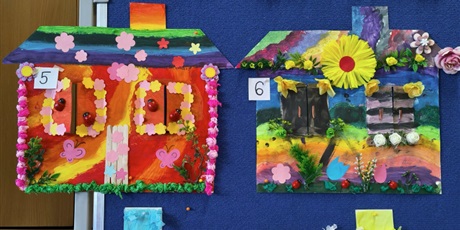 Powiększ grafikę: Tablica, na której wiszą kolorowe prace plastyczne przedstawiające domy pani wiosny.