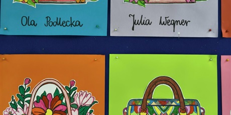 Powiększ grafikę: Granatowa tablica ścienna, na której znajdują się kolorowe prace konkursowe pt. "Projekt damskiej torebki".