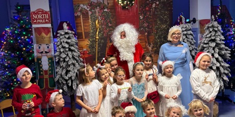 Powiększ grafikę: Zdjęcie grupowe z Mikołajem. Dzieci z grupy 0b przebrane za śnieżynki pozują z Mikołajem i Królową Śnieżynek.