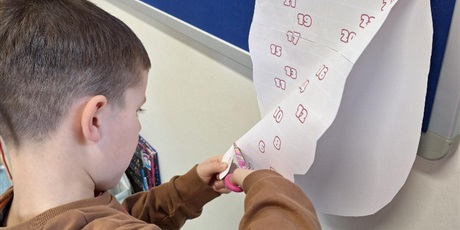 Powiększ grafikę: Chłopiec odcina nożyczkami brodę Mikołaja. Na niej zaznaczone są liczby.