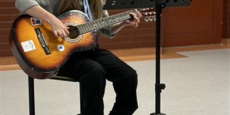 Powiększ grafikę: Dziewczynka grająca na gitarze - prezentacja talentu.