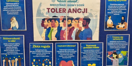 Powiększ grafikę: Granatowa tablica informacyjna, na której znajdują się plakaty dotyczące Międzynarodowego Dnia Tolerancji.