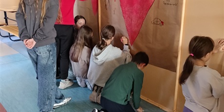 Powiększ grafikę: Uczniowie malują na ścianie Mural Przyjaźni. Jest na nim wielkie czerwone serce.