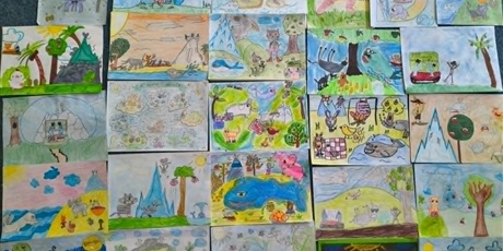 Powiększ grafikę: Kilkanaście kolorowych prac konkursowych leży obok siebie na dywanie. Znajdują się na nich koty, słonie, kury, wieloryby itp.