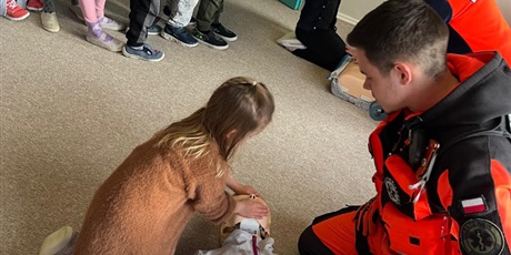 Powiększ grafikę: Dzieci klęczą przy manekinach i samodzielnie próbują udzielać pierwszej pomocy.